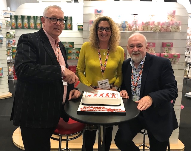 Above: Cardgains’ joint md Chris Dyson (left) with marketing director Penny Shaw and Jim Girvan, general sales manager with the buying group’s 30th anniversary cake that was shared on the stand at the Spring Fair. 