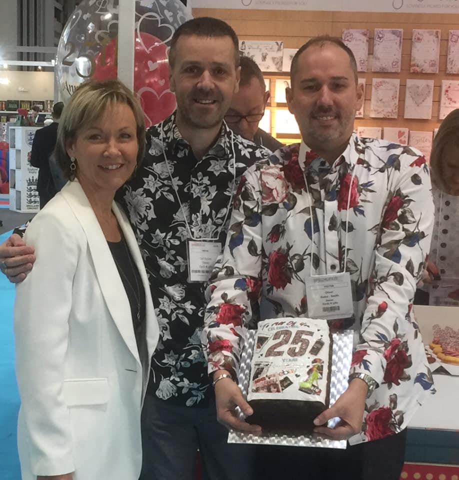 Above: Cherry Orchard’s retail customers Carl Dunne and Oliver Guise-Smith at the recent Spring Fair at which the chaps presented Jackie Collins with a cake and cupcakes to celebrate the company’s 25th anniversary. 