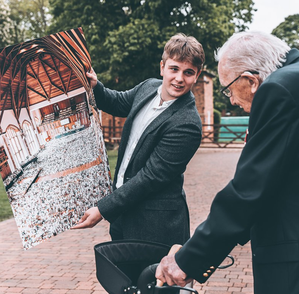 Above: Captain Tom being shown the 160,000 cards that members of the general public had sent him for his 100th birthday by his grandson Benjie.  