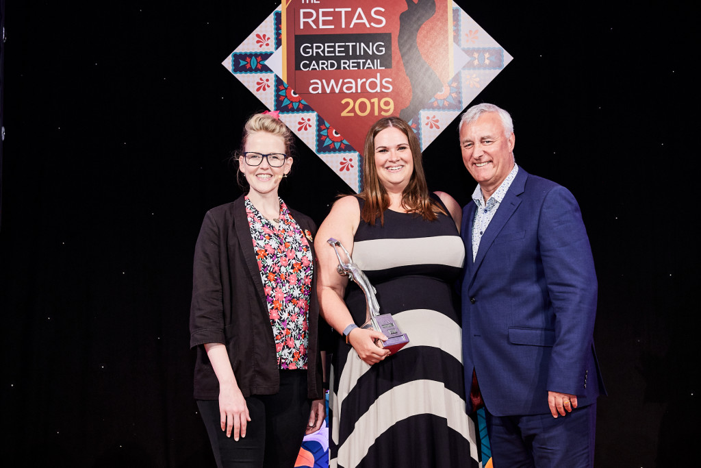 Above: Carly Pearson (middle) collecting the award for Best Supermarket Retailer of Greeting Cards at The Retas 2019 awards from Simon Boyd, operations director of PG Live, sponsor of the award category.