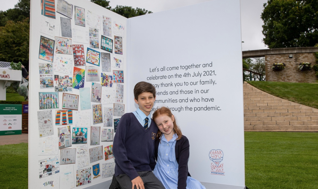 Above: Two school children showing the inside of the card which features designs from different schools.