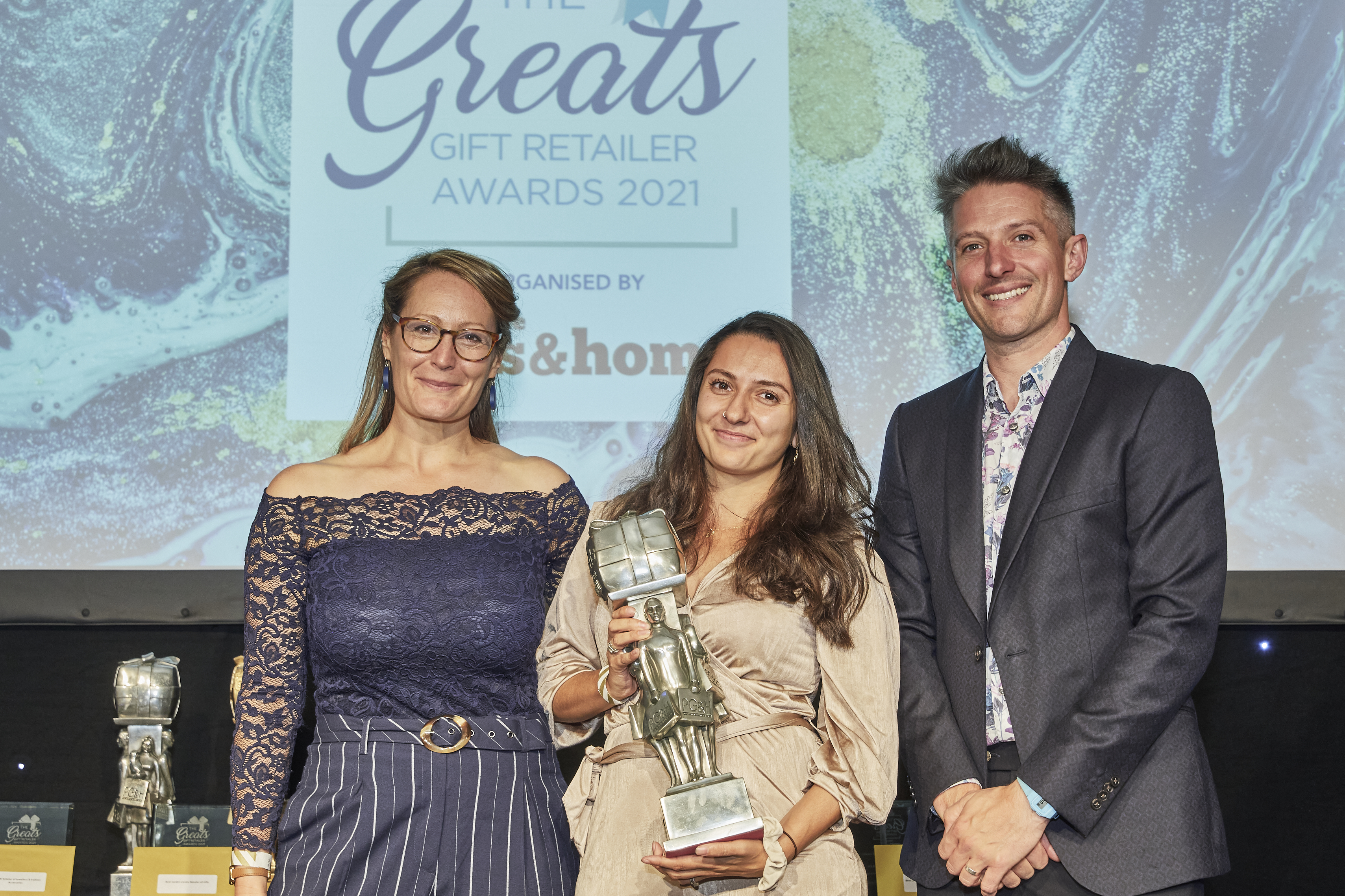 Above: Priya Aurora-Crowe (centre) with The Greats trophy that was presented to her by Helena Mansell-Stopher, founder and ceo of Products of Change, sponsor of the award category. Stuart Goldsmith, host of the event is also pictured.