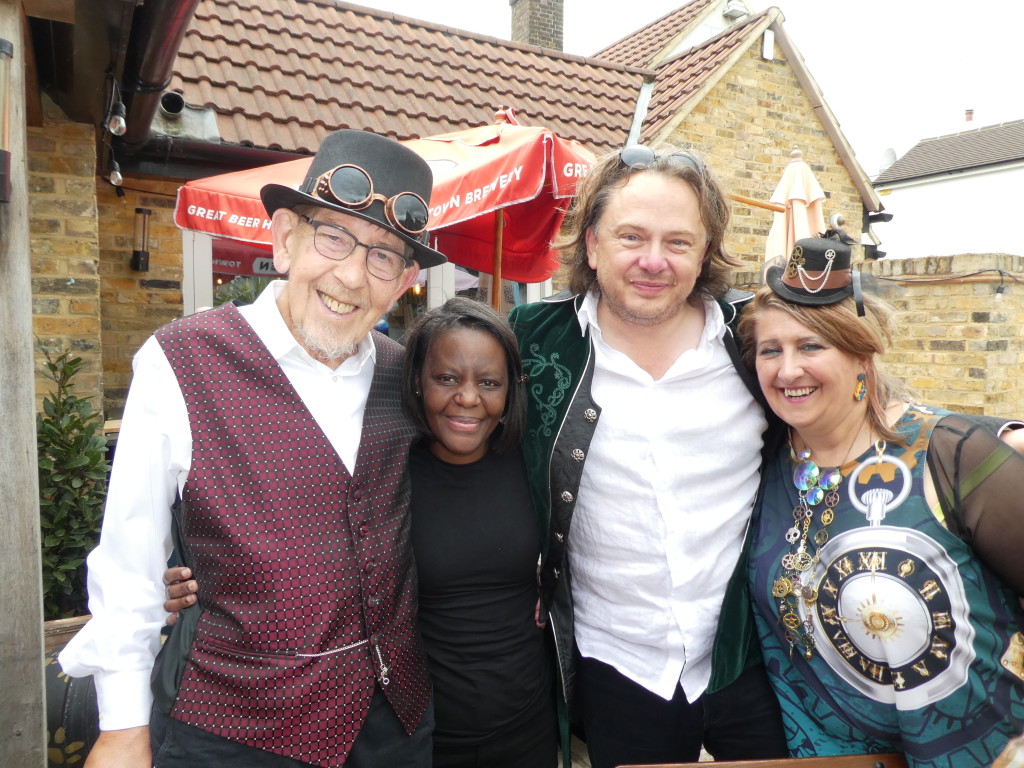 Above: Paul Steele (left) at the Steampunk-themed memorial event for David Hicks in June with (right-left) agent Rosie Trow, M.E.G’s Michael Gray and John Lewis’ Branca Neto