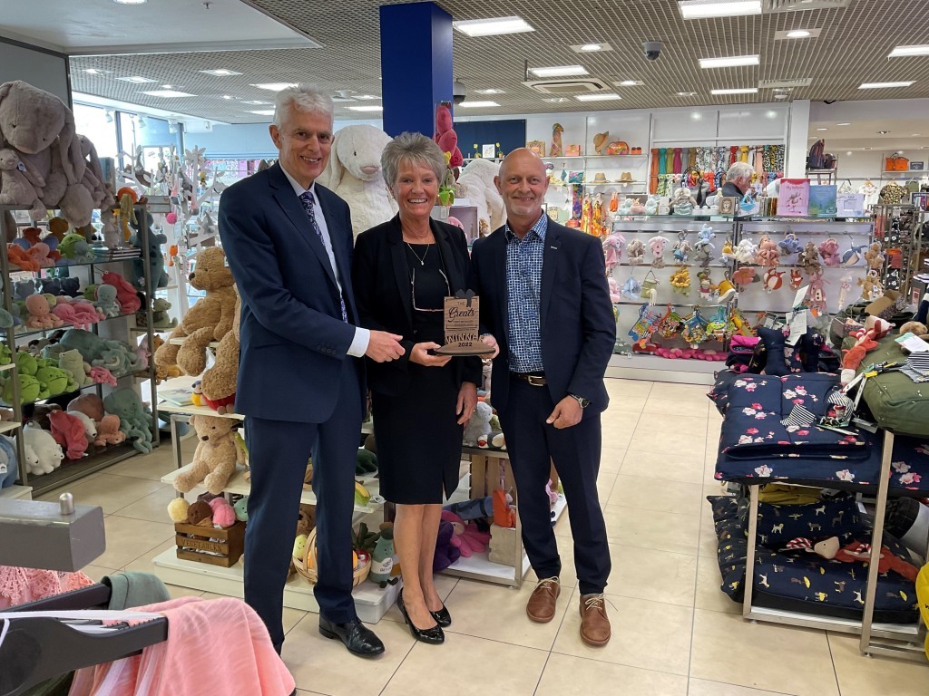 Above: David Austin (left) with Austins’ fashion manager Julie King and merchandise director Paul Lewis and the retailer’s 2022 Greats trophy